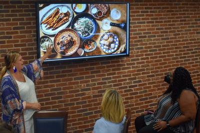 Food-travel photographer Jennifer Chase, left, talks about camera angles at the July 20, 2022, Photography Team food photography dinner. Photo: Alan Kotok