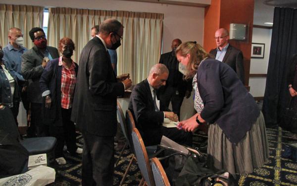Eric Holder signs a copy of his book at May 12 event