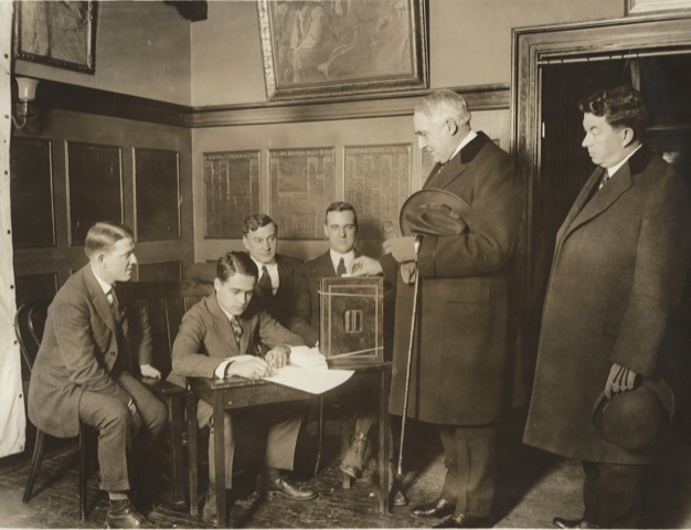 President Warren Harding casts a vote in Club's election, N.C. Wyeth painting on wall above head