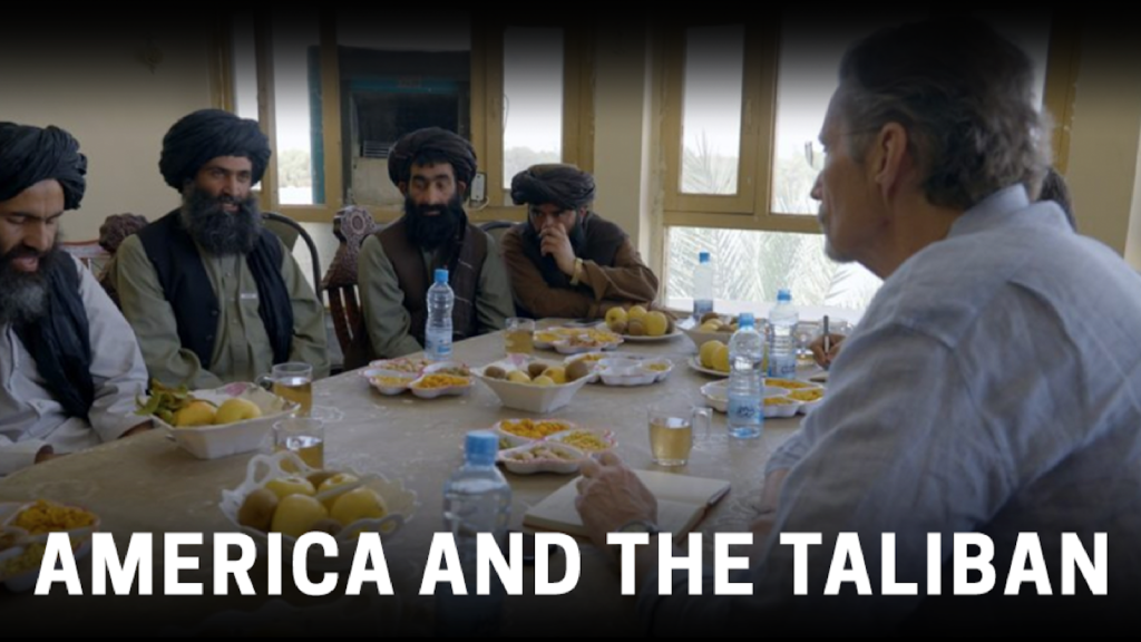 Screen grab of reporter sitting around a table with Taliban
