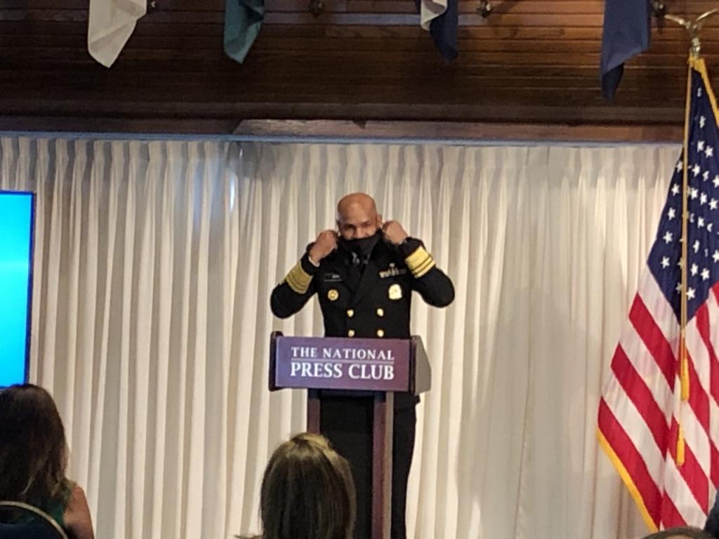 U.S. Surgeon General Jerome Adams removes his mask before speaking.