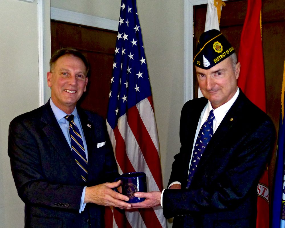 Photo of Gen. Jeff Phillips (ret.) receiving Press Club mug from Post 20 leader Tom Young.