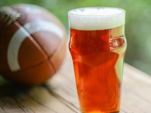 A photo of a glass of beer and a football